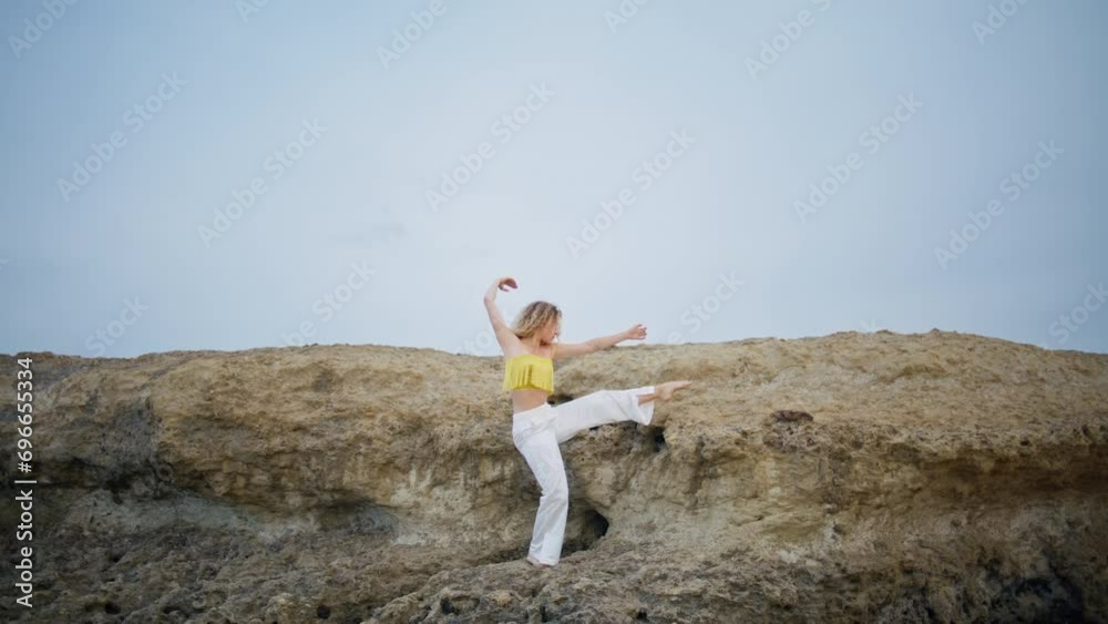 Gentle woman dancer moving flexible body raising leg on stony rock. Girl dancing Gentle woman dancer moving flexible body raising leg on stony rock. Girl dancing