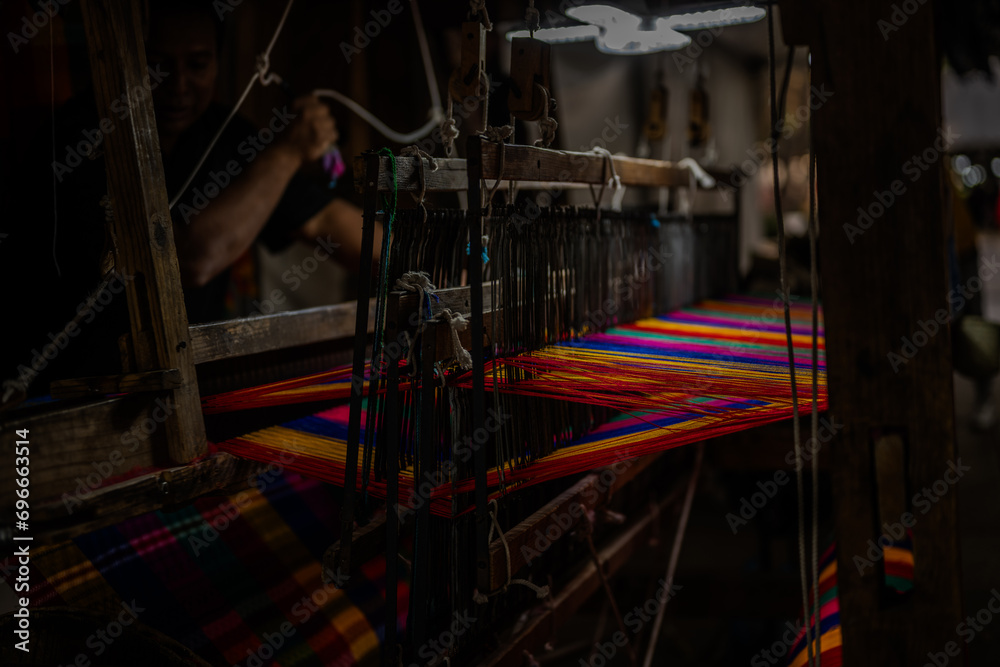 Artesano mexicano creando un tejido de colores con un telar antiguo