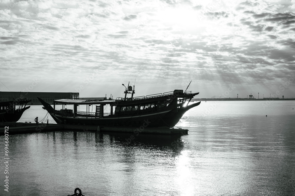 Fototapeta premium Black and white photo of Traditional boats called Dhows are anchored in the old Doha port