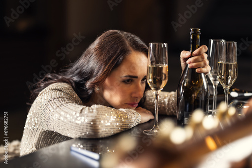 An unhappy woman gets drunk on alcohol in a bar because she just broke up with her boyfriend or husband