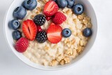 Bowl with tasty oatmeal and berries on light background. Healthy breakfast, Top view.
