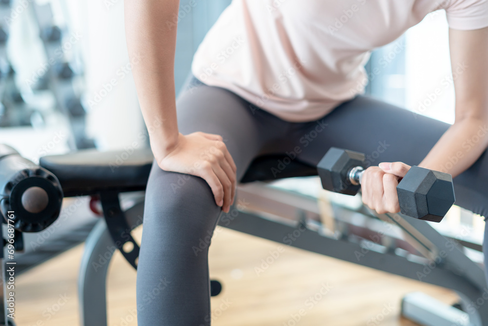 woman is lifting the Dumbbell up and down for strengthen her arms and ...