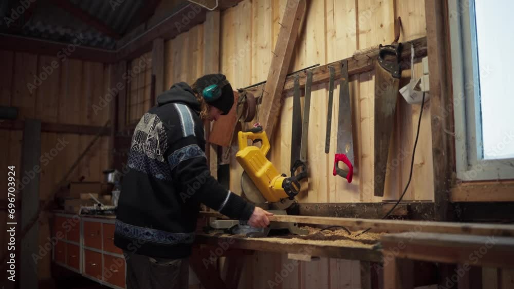 A Man is Sawing Through a Piece of Lumber in Indre Fosen, Trondelag County, Norway - Static Shot A Man is Sawing Through a Piece of Lumber in Indre Fosen, Trondelag County, Norway - Static Shot