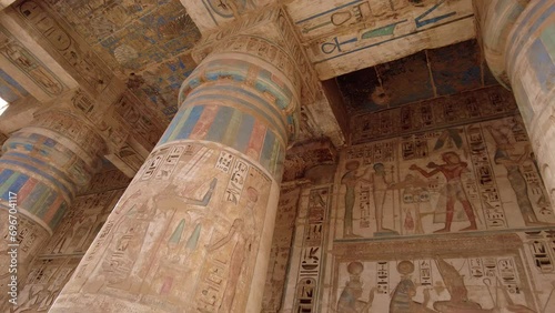 Luxor, Egypt - November 26 2023: Colorful paintings and hieroglyphs ornate the columns in the temple of Ramesses III in Medinet Habu on Luxor westbank in the valley of Nobles in upper Egypt photo