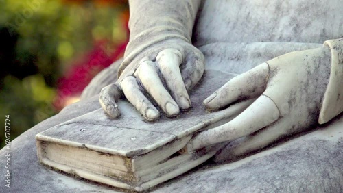 Close-up of a book and hands resting on a lap. Monument of Empress Elisabeth of Austria (Sissi monument) in Meran - Merano, South Tyrol, Italy photo