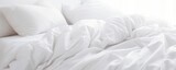 A white folded duvet resting on a bed with a white background.