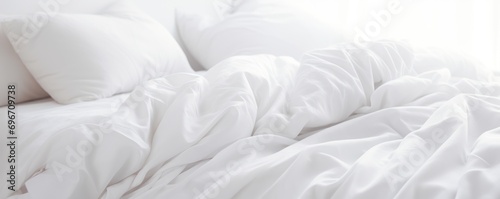 A white folded duvet resting on a bed with a white background. photo
