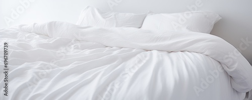 Capture the essence of purity and comfort as a white folded duvet graces the backdrop of a pristine white bed.




 photo