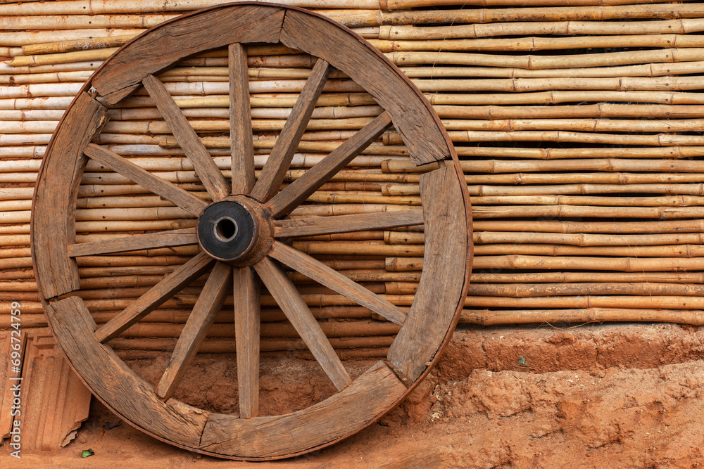 A wheel of a bullock cart just outside of beautiful traditional tribal bamboo cottage or hut at Kanger valley national park, Chattisgarh, India. A wheel of a bullock cart just outside of beautiful traditional tribal bamboo cottage or hut at Kanger valley national park, Chattisgarh, India.