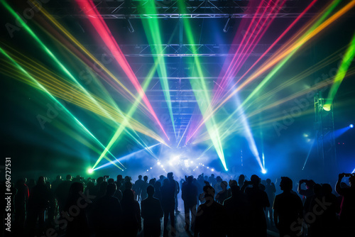 Laser beams are colorfully produced at a concert. The audience gets excited and cheers. Light for events and stages.