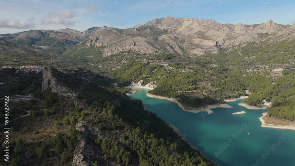 A blue lake drone view surrounded by mountains. Located near the castle of Guadalest, Alicante, Spain