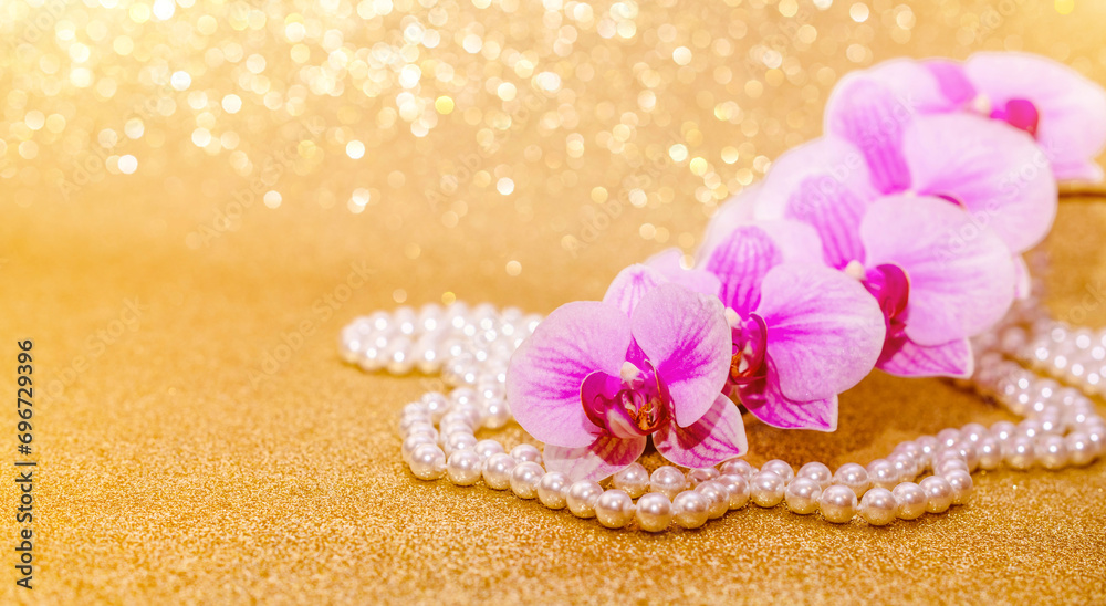 purple Orchid and pearl necklace on a shiny gold background
purple Orchid and pearl necklace on a shiny gold background