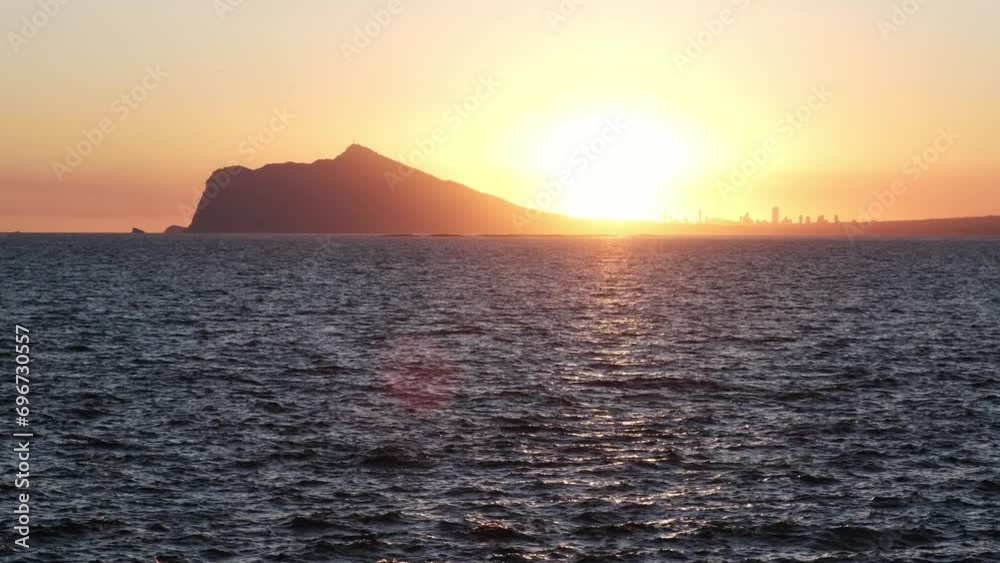 Sunset on the coastal city of Calp with a view of Benidorm. The coast of the Mediterranean Sea. Sunset on Costa Blanca. Sunset on the coastal city of Calp with a view of Benidorm. The coast of the Mediterranean Sea. Sunset on Costa Blanca.