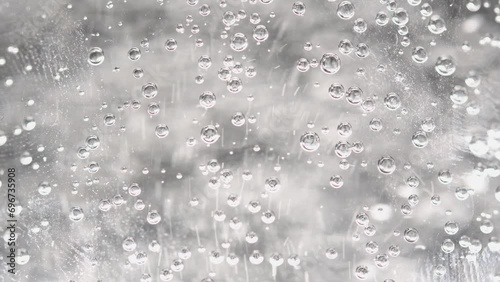 Sparkling water is poured into a glass beaker, blurred bubbles, light background photo