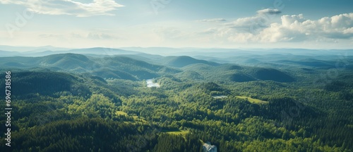 Bird's-eye panoramic shot of a spacious forest landscape from a hill photo