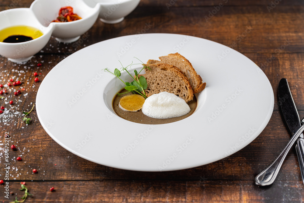 Crostini Fegatini on white porcelain plate on wooden table Crostini Fegatini on white porcelain plate on wooden table