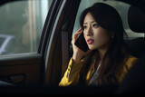 An Asian businesswoman making a phone call in the car on the way to a business meeting