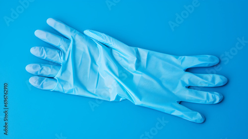 Pair of latex medical gloves and protective mask on blue background
