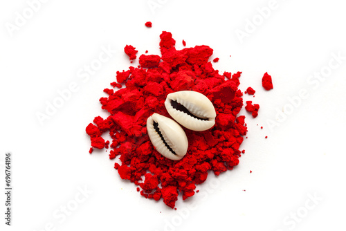 Top view of Cowrie (Cypraea chinensis) placed over auspicious red-colored Sindoor (vermilion) or kumkum isolated on a white background. photo