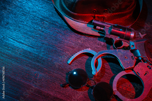 Police inspector handcuffs and gun on the black table flat lay background. Top view. Security. Secret service. photo