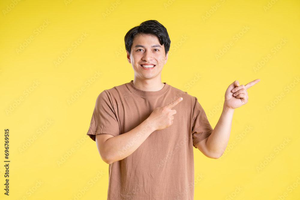 Portrait of asian man posing on yellow background Portrait of asian man posing on yellow background