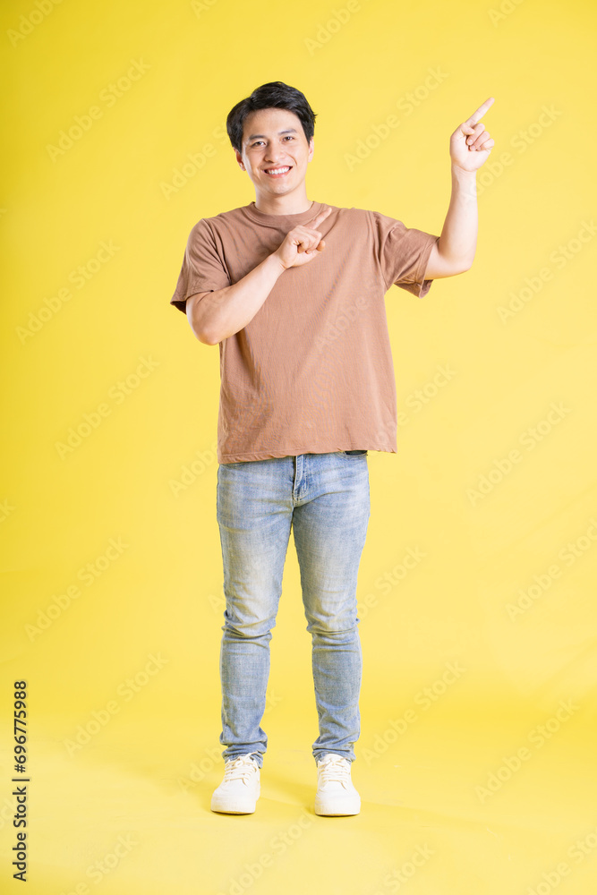 Portrait of asian man posing on yellow background Portrait of asian man posing on yellow background