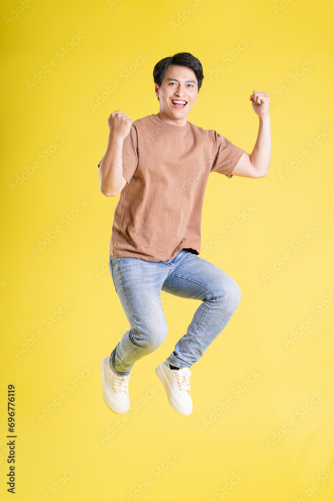 Portrait of asian man posing on yellow background Portrait of asian man posing on yellow background