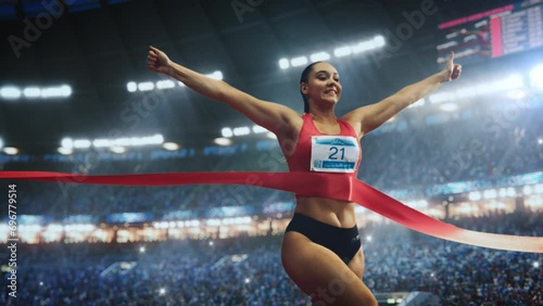 Strong Female Athlete Performing at Her Limit, Finishing a Competitive Run, Crossing the Finish Line with a Red Ribbon. Cinematic Sports Footage at a Crowded Arena with Spectators. Super Slow Motion photo