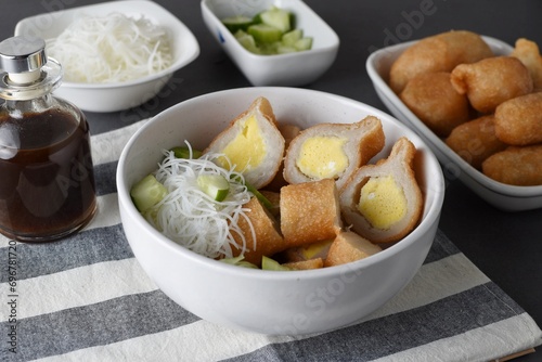 Pempek  on white plate with vermicelli and cuko sauce. Pempek, mpek-mpek or empek-empek is a savory Indonesian fishcake delicacy, made of fish and tapioca, from Palembang, South Sumatera, Indonesia.