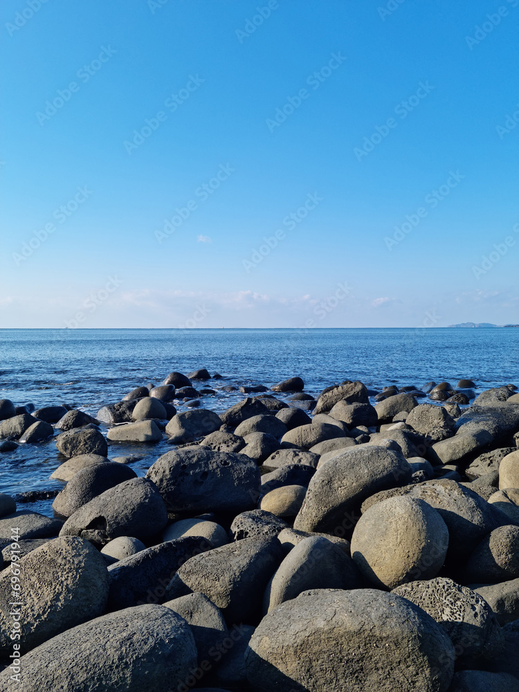 Jeju Island's sea with black basalt rocks.