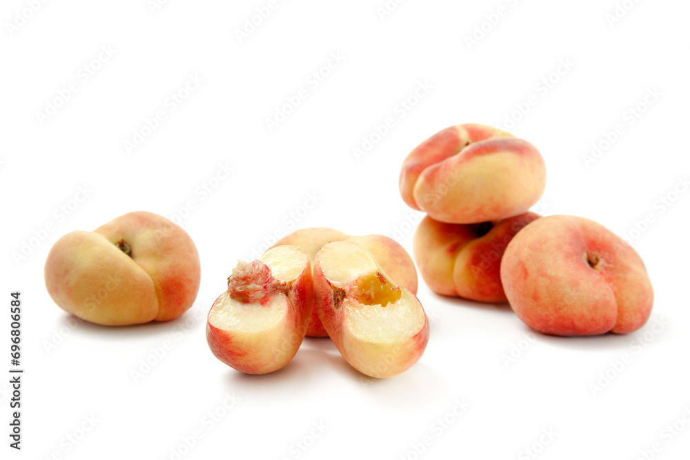 Half and several whole saturn peaches or flat peaches isolated on white background with clipping path.. Half and several whole saturn peaches or flat peaches isolated on white background with clipping path..
