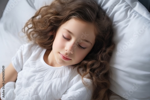 Brunette little girl sleeping well on white pillow in bed