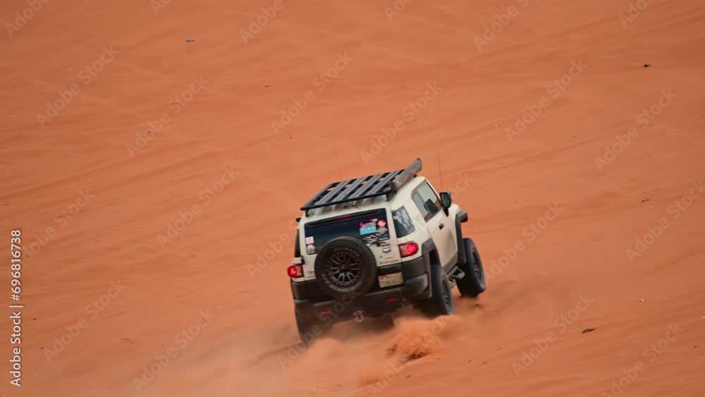 Riyadh, Saudi Arabia – November 1st 2023: Offroad vehicles bashing and climbing desert safari dunes ,red sand dunes adventurous ride 4x4 vehicle in Riyadh. Modified car, customized vehicle