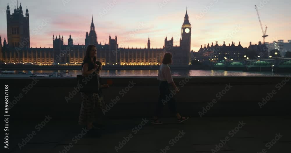 Camera follows mother with son and daughter strolling along river bank, epic Big Ben in background during stunning dawn. Camera follows mother with son and daughter strolling along river bank, epic Big Ben in background during stunning dawn.
