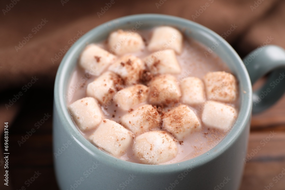 Cup of aromatic hot chocolate with marshmallows and cocoa powder on table, closeup Cup of aromatic hot chocolate with marshmallows and cocoa powder on table, closeup
