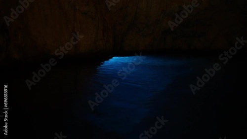 Amazing view of sunlight shining through water surface inside of Grotta dello Smeraldo on Amalfi Coast. Light becomes tinged with magical emerald color that sends sparkling reflections up cave walls. photo