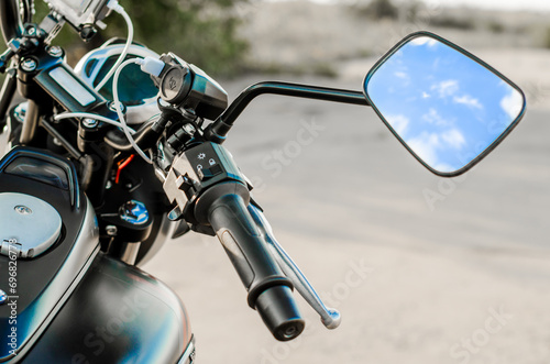 reflection of the nab and clouds in the motorcycle mirror, motorcycle steering wheel and motorcycle fuel tank