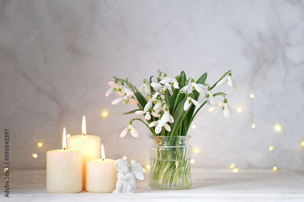 fairy girl figurine, snowdrops flowers and candles on table, light abstract background. spring season. Romantic composition with flowers. relaxation, dreams, love, hope concept fairy girl figurine, snowdrops flowers and candles on table, light abstract background. spring season. Romantic composition with flowers. relaxation, dreams, love, hope concept