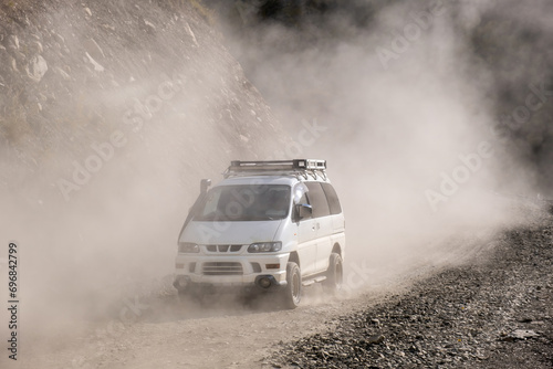 minibus on a dusty road in the mountains