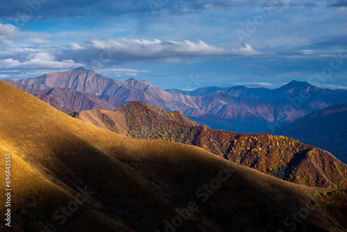 mountainous landforms at sunset meadows, warm shades of autumn mountains