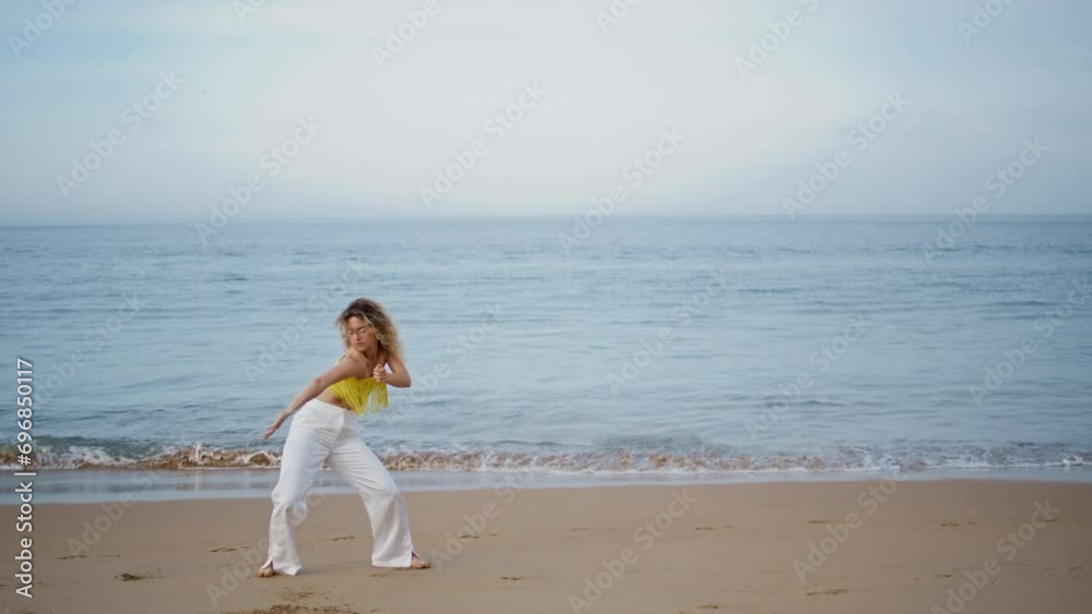 Girl performing modern dance on evening ocean shore. Woman dancer moving body Girl performing modern dance on evening ocean shore. Woman dancer moving body
