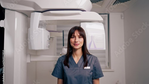 portrait of a beautiful young female doctor dentist or radiologist in uniform standing in the beauty and health clinic photo