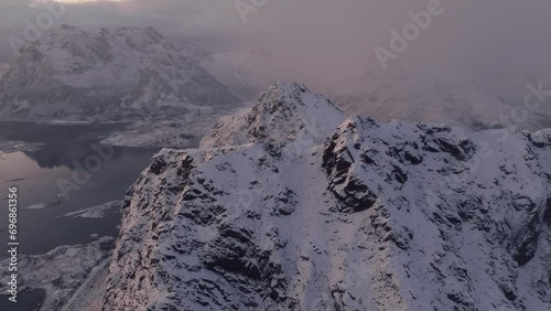 The winter charm of Mount Norway Lofoten, where a snow-covered mountain peak stands against the cold backdrop of clear blue skies. photo