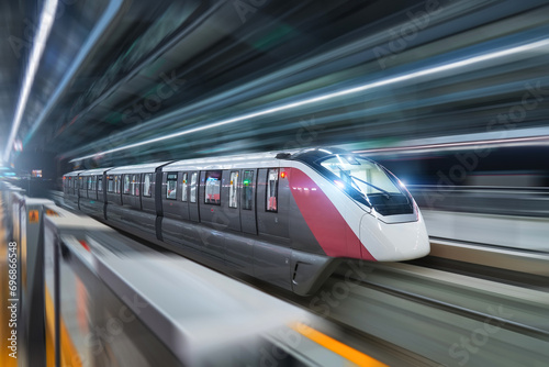 Photos Modern high speed monorail train with bright headlights passes through the station
