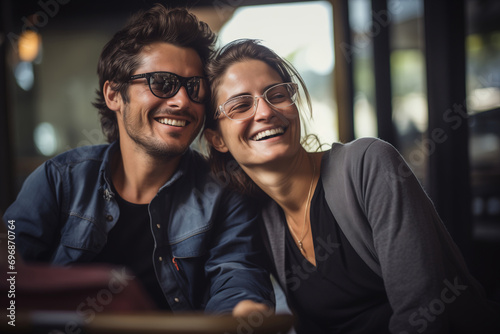 Happy couple in love in a cafe, hugging together, positive man and woman looking away