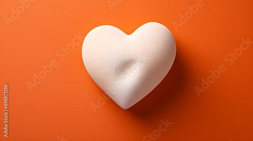 Top View of a White Stone Heart on a orange Background. Romantic Template with Copy Space