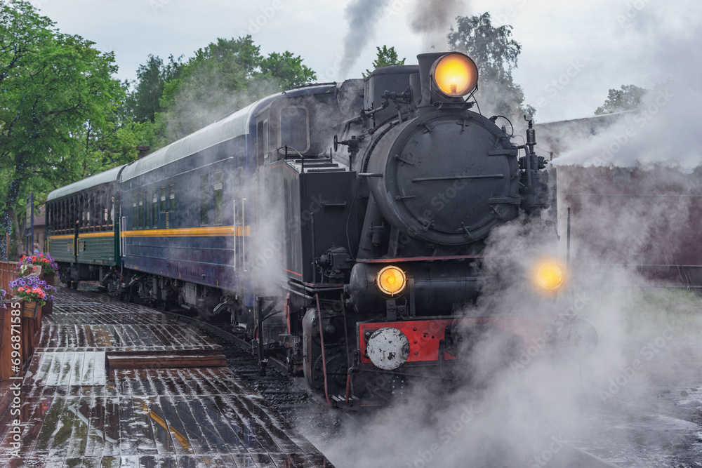 Retro steam train approaches to the platform. Retro steam train approaches to the platform.