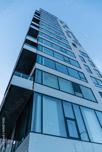 Modern building in the city. Skyscraper with balconies and large glass windows.