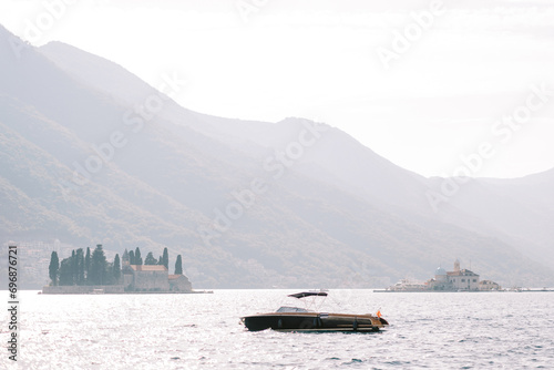 Black motor yacht sails past the island of St. George in the Bay of Kotor. Montenegro