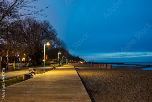 Photography wooden boardwalk and street lights along a sand beach at daybreak shot in kew be